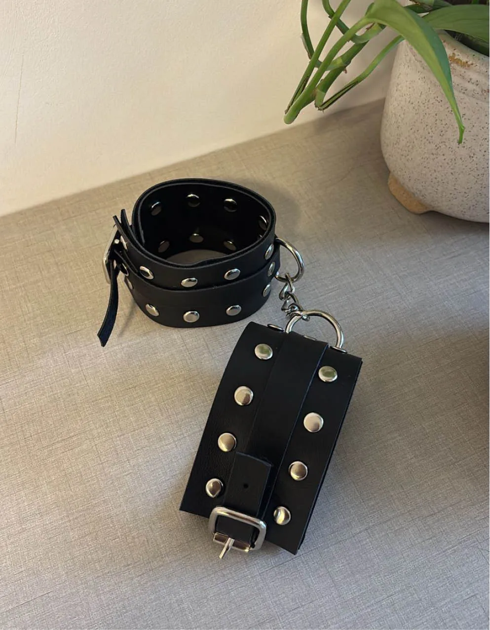 Esposas de cuero con cadena metálica y tachas